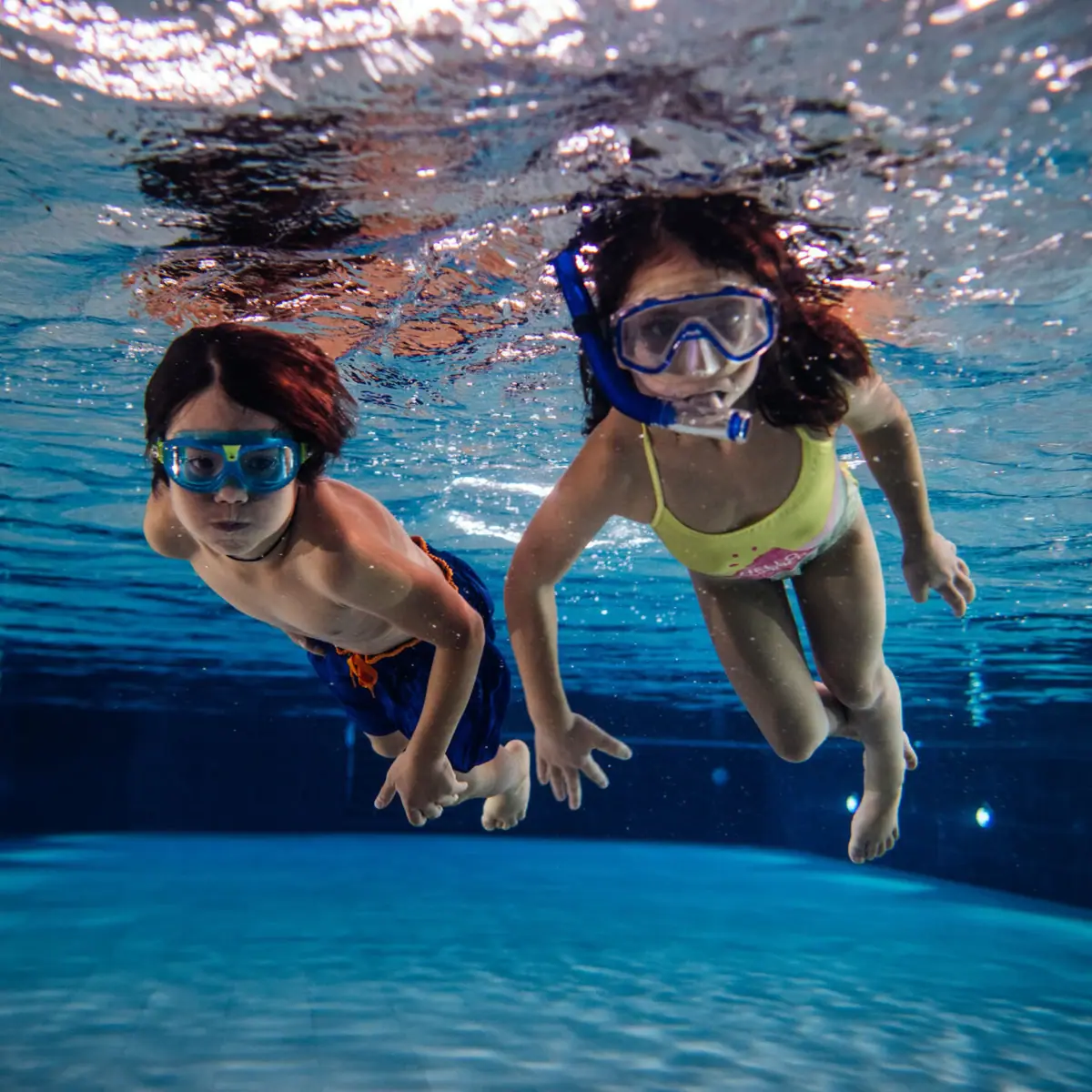 Zwei Kinder schwimmen im Pool im Badehaus Werfenweng.