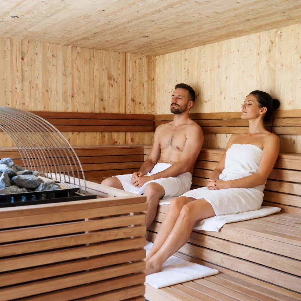 Ein Mann und eine Frau sitzen in einer Sauna.