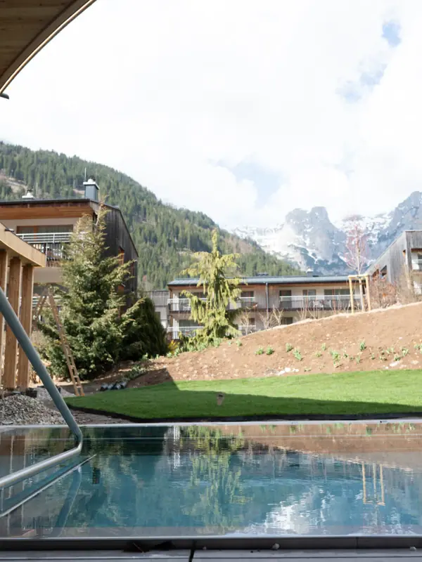 Ein Pool im Hinterhof eines Gebäudes mit Bergen im Hintergrund.