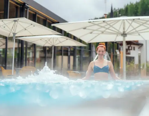 Frau schwimmt in einem Außenpool.