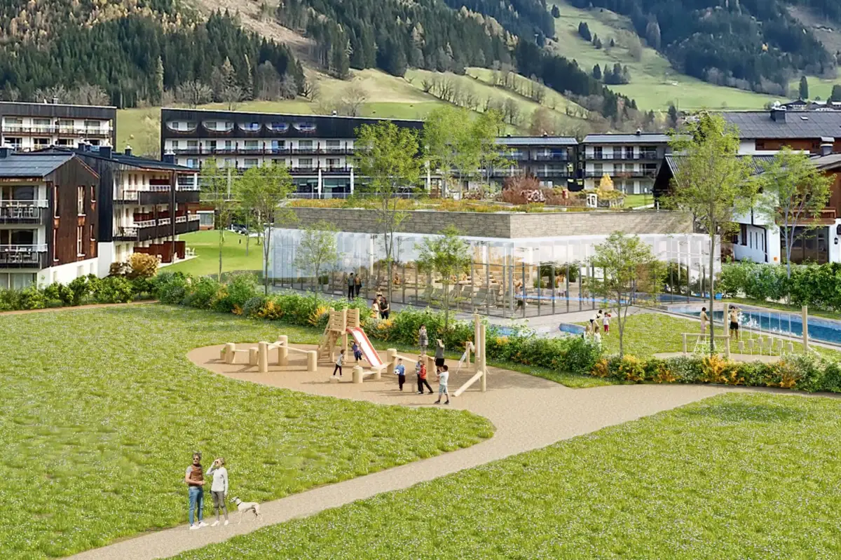Eine Gruppe von Menschen spielt auf einem Spielplatz vor dem Badehaus Werfenweng.
